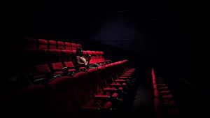 Picture of a person watching a movie in the theatre by Karen Zhao